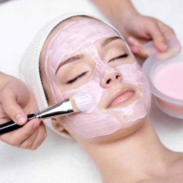 Hier können Sie das Auftragen einer rosafarbigen Hautmaske als Basic Treatment Leistung der Gesichtsbehandlung in Frickenhausen erkennen.